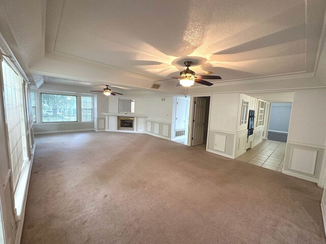 1906 Carolyn Dr, Jonesboro, AR 72404 - unfurnished living room with ceiling fan, a decorative wall, a raised ceiling, a fireplace, and light colored carpet
