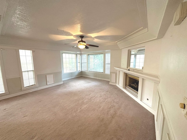 1906 Carolyn Dr, Jonesboro, AR 72404 - unfurnished living room with a textured ceiling, a glass covered fireplace, ceiling fan, and light colored carpet