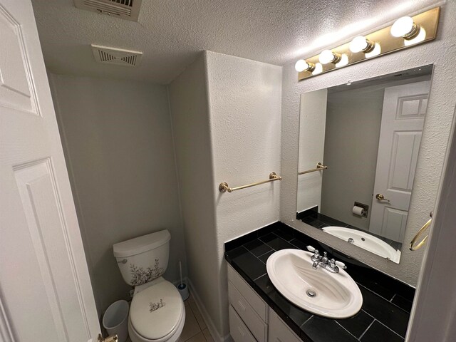 1906 Carolyn Dr, Jonesboro, AR 72404 - half bathroom featuring toilet, vanity, a textured ceiling, visible vents, and tile patterned flooring