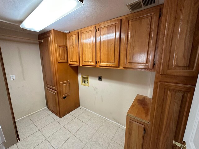 1906 Carolyn Dr, Jonesboro, AR 72404 - laundry room featuring cabinet space, visible vents, light tile patterned floors, electric dryer hookup, and hookup for a washing machine