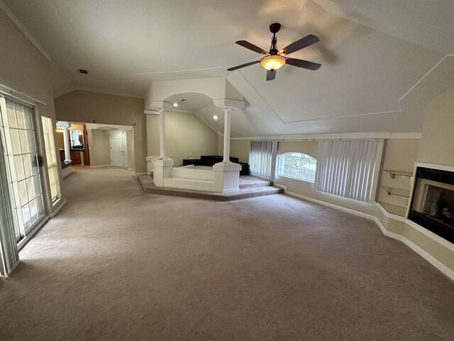 1906 Carolyn Dr, Jonesboro, AR 72404 - unfurnished living room with decorative columns, vaulted ceiling, ceiling fan, light carpet, and a glass covered fireplace