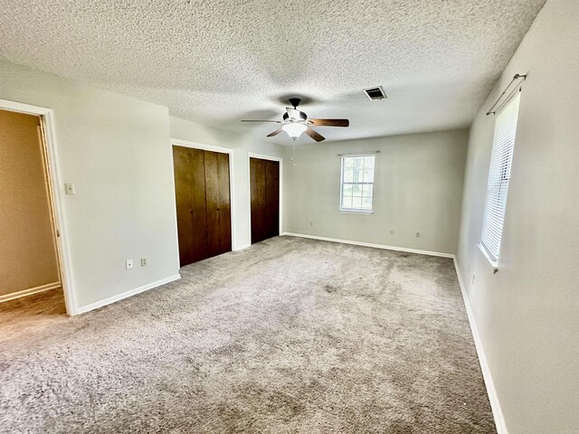 12921 Barth Rd, Alexander, AR 72002 - unfurnished bedroom with two closets, carpet flooring, a textured ceiling, baseboards, and a ceiling fan