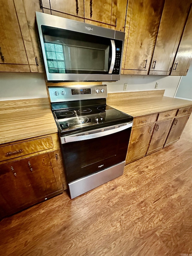 12921 Barth Rd, Alexander, AR 72002 - kitchen featuring stainless steel appliances, wood finished floors, and brown cabinets