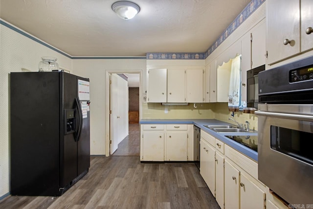 kitchen featuring a sink, white cabinets, dark wood finished floors, stainless steel oven, and black refrigerator with ice dispenser