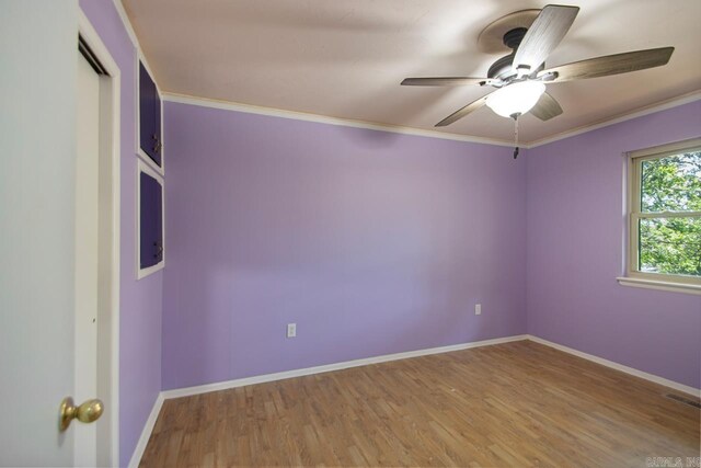 unfurnished room featuring wood finished floors, visible vents, crown molding, a ceiling fan, and baseboards