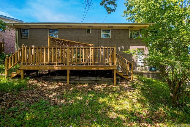 back of property featuring stairs, a wooden deck, and brick siding