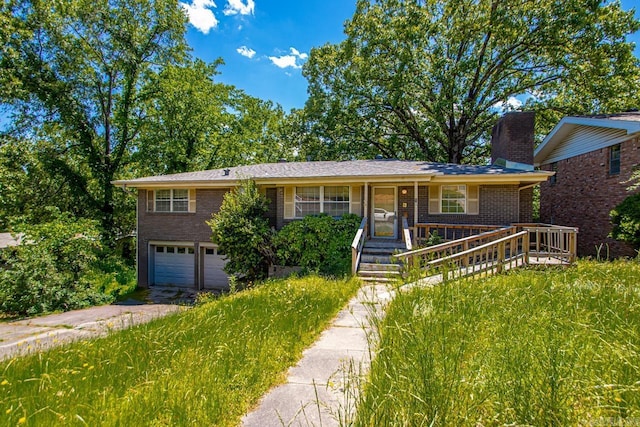 single story home with covered porch, a garage, a chimney, brick siding, and driveway