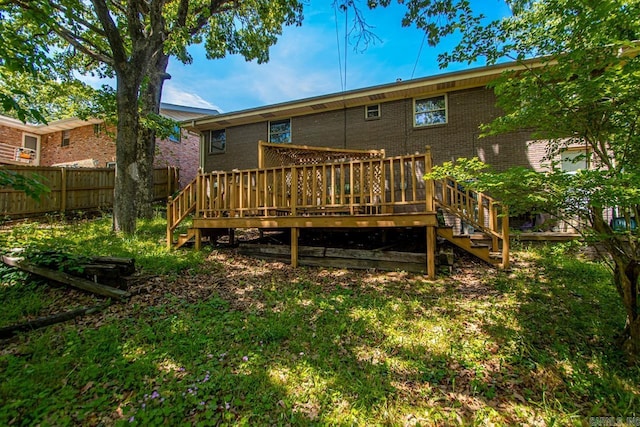rear view of property featuring stairs, a deck, brick siding, and fence