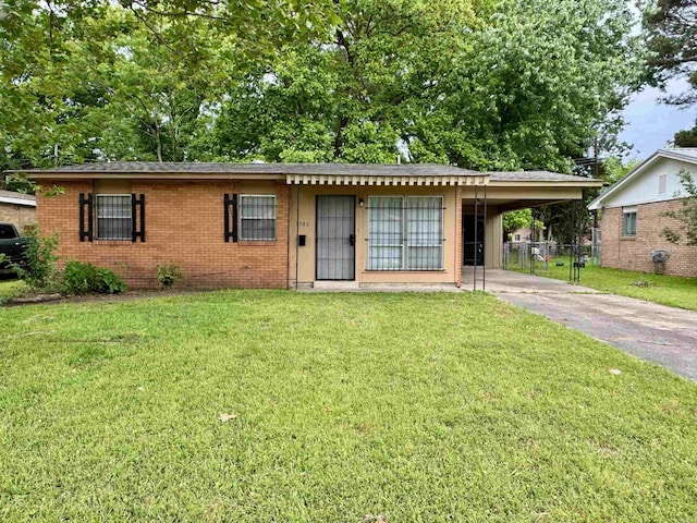 ranch-style house with a front yard, an attached carport, brick siding, and driveway