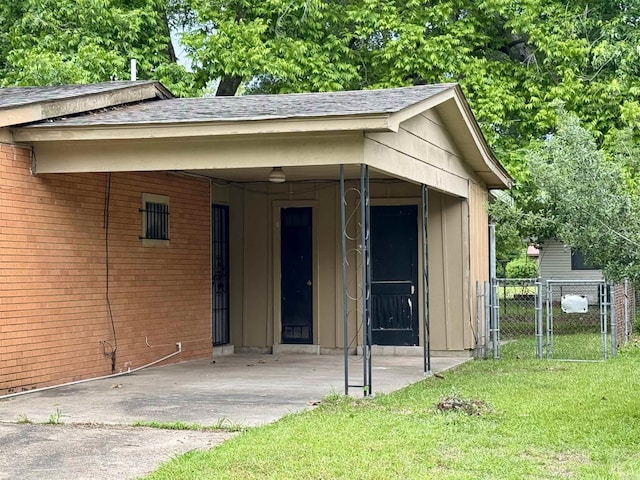 exterior space with a yard, fence, a shingled roof, and brick siding