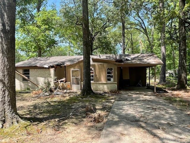 view of front of house featuring concrete driveway, brick siding, and an attached carport
