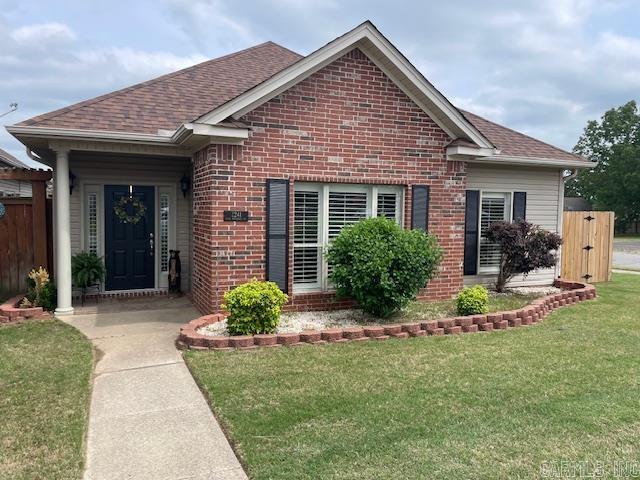 2241 Sage Meadows Cir, Sherwood, AR 72120 - view of front of property featuring fence, a shingled roof, a front lawn, and brick siding