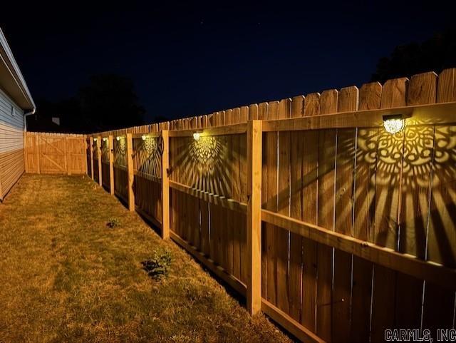 2241 Sage Meadows Cir, Sherwood, AR 72120 - yard at night with a fenced backyard