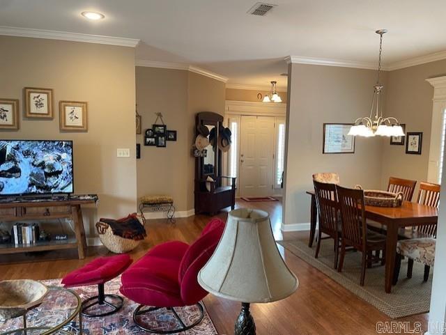 2241 Sage Meadows Cir, Sherwood, AR 72120 - living room featuring wood finished floors, ornamental molding, visible vents, a chandelier, and baseboards