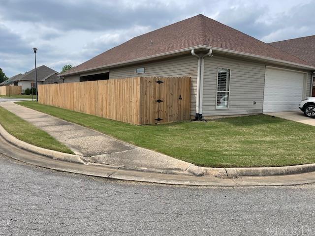 2241 Sage Meadows Cir, Sherwood, AR 72120 - view of side of home featuring a lawn, an attached garage, fence, and concrete driveway