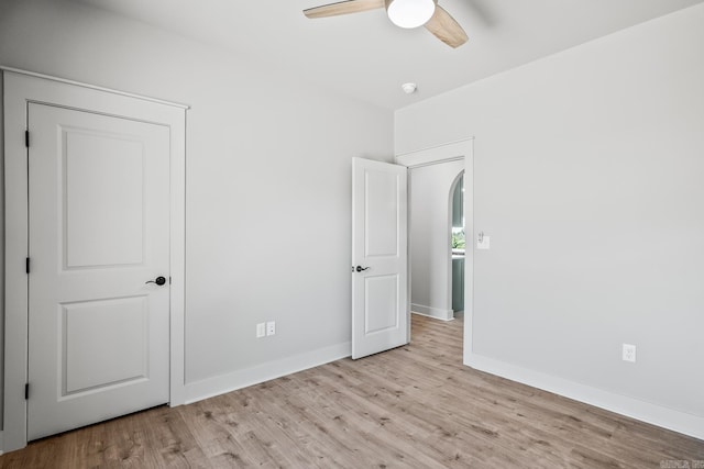 54 Lieblong Rd, Greenbrier, AR 72058 - unfurnished bedroom featuring arched walkways, baseboards, ceiling fan, and wood finished floors