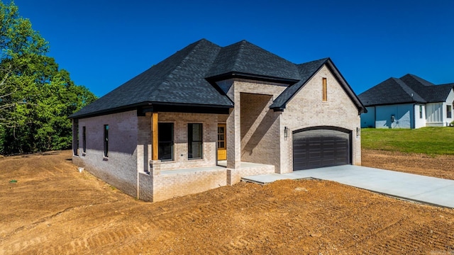 54 Lieblong Rd, Greenbrier, AR 72058 - french country home featuring concrete driveway, a garage, a shingled roof, and brick siding