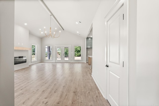 54 Lieblong Rd, Greenbrier, AR 72058 - unfurnished living room with high vaulted ceiling, light wood-type flooring, a notable chandelier, baseboards, and a glass covered fireplace