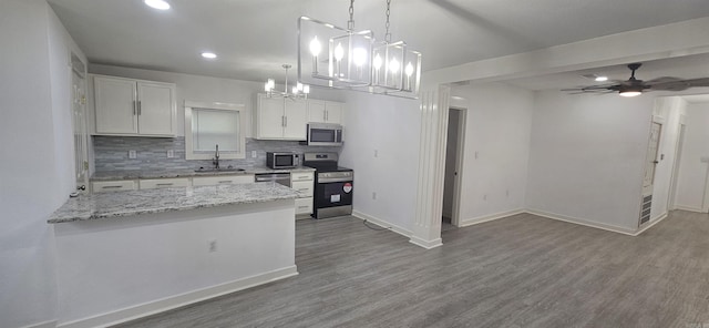 2720 S Spring St, Little Rock, AR 72206 - kitchen with a sink, stainless steel appliances, tasteful backsplash, wood finished floors, and white cabinets
