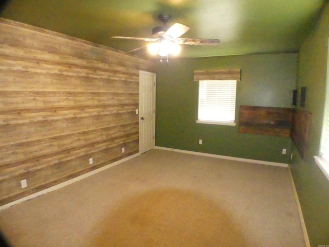 137 Gone Fishin Ln, Mena, AR 71953 - spare room featuring a ceiling fan, wooden walls, carpet, and baseboards