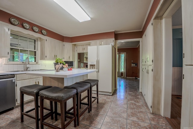 5 Southern Pines Cv, Pine Bluff, AR 71603 - kitchen featuring a sink, white fridge with ice dispenser, backsplash, light countertops, and stainless steel dishwasher