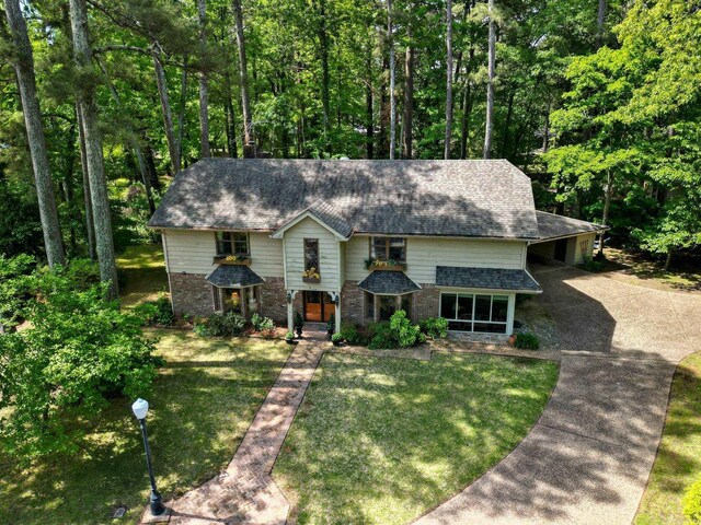 5 Southern Pines Cv, Pine Bluff, AR 71603 - view of front of home featuring brick siding, concrete driveway, a carport, a front lawn, and a shingled roof