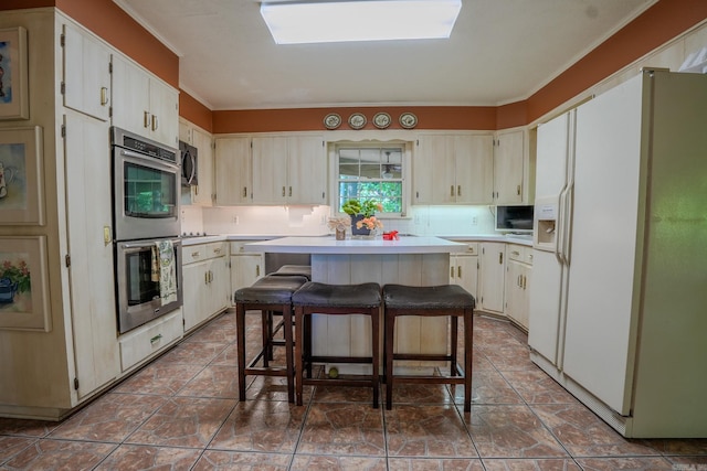 5 Southern Pines Cv, Pine Bluff, AR 71603 - kitchen featuring stainless steel appliances, a center island, a kitchen breakfast bar, crown molding, and light countertops
