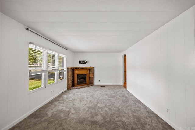 1504 W Woodson Lateral Rd, Hensley, AR 72065 - unfurnished living room featuring a fireplace with raised hearth and carpet