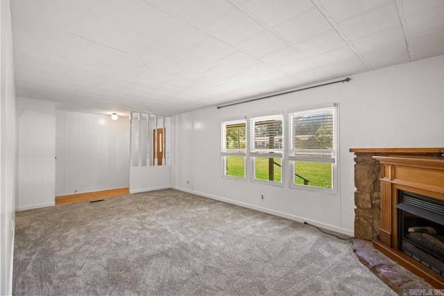 1504 W Woodson Lateral Rd, Hensley, AR 72065 - unfurnished living room featuring carpet flooring, visible vents, baseboards, and a fireplace with raised hearth