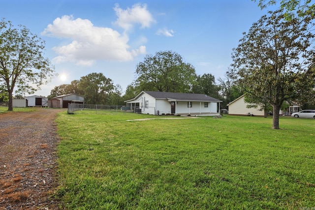 view of yard featuring fence, an outdoor structure, a garage, a pole building, and dirt driveway