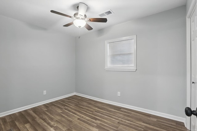 empty room featuring baseboards, ceiling fan, visible vents, and dark wood-style floors