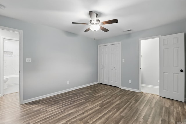 unfurnished bedroom featuring wood finished floors, a ceiling fan, a closet, visible vents, and baseboards