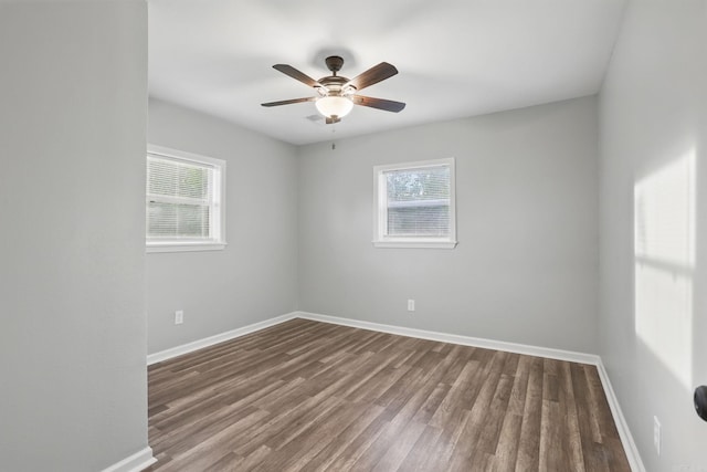 empty room with baseboards, a healthy amount of sunlight, and wood finished floors