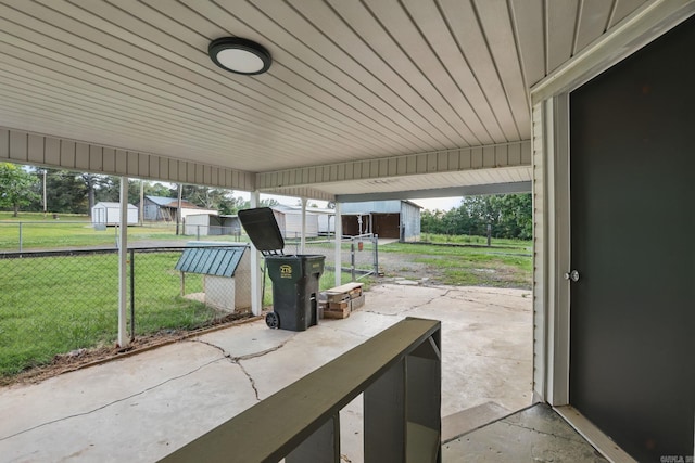 view of patio featuring an outdoor structure, a storage shed, and fence