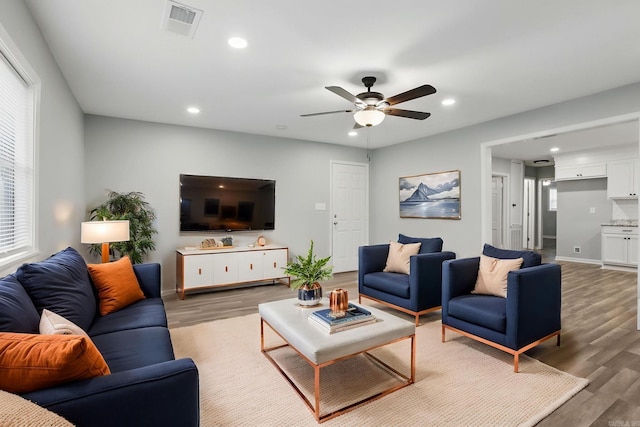 living room with light wood finished floors, visible vents, and recessed lighting