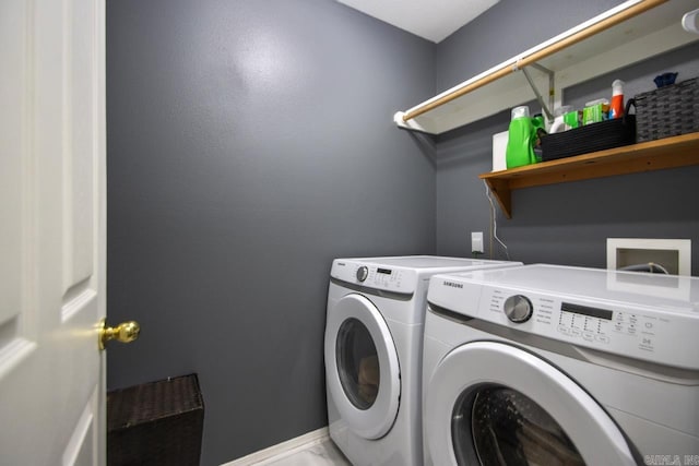 laundry area with baseboards, washing machine and dryer, and laundry area