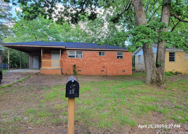 ranch-style house featuring driveway, a carport, brick siding, and crawl space