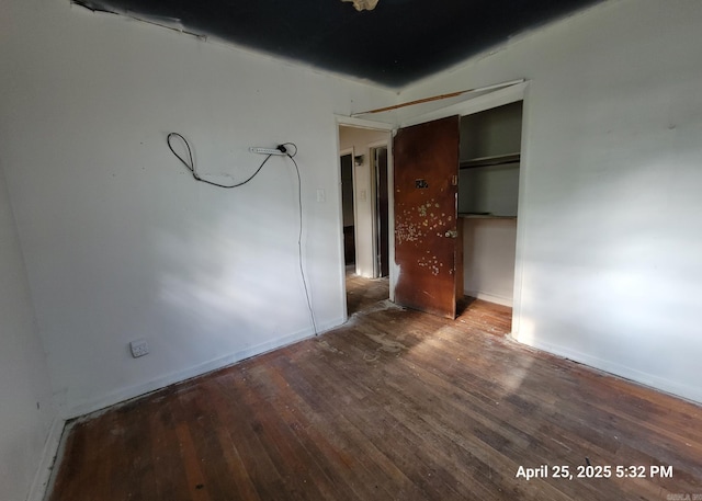 unfurnished bedroom with baseboards and hardwood / wood-style floors