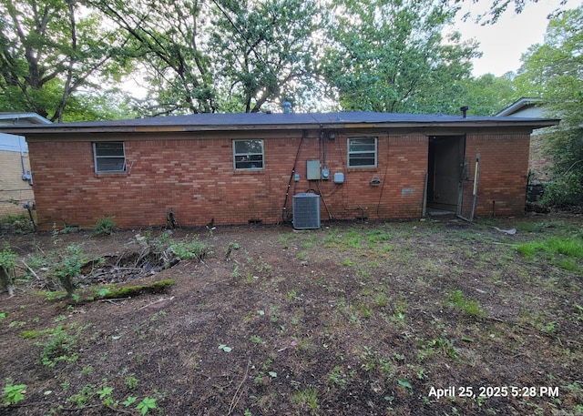 rear view of property with central AC unit and brick siding