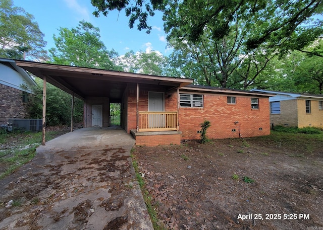 view of front of home with brick siding, crawl space, concrete driveway, a carport, and central AC unit
