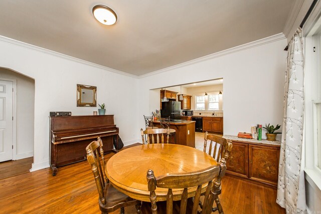 2420 Marshall St, Little Rock, AR 72206 - dining area with ornamental molding, arched walkways, baseboards, and wood finished floors