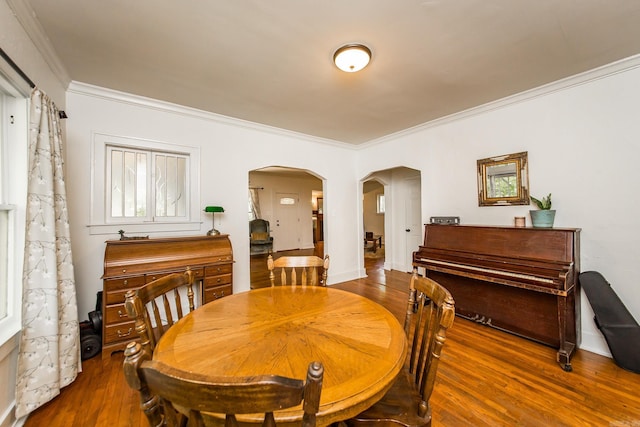 2420 Marshall St, Little Rock, AR 72206 - dining space featuring crown molding, arched walkways, baseboards, and wood finished floors