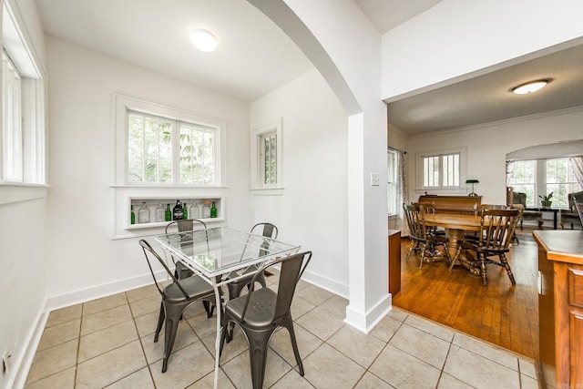 2420 Marshall St, Little Rock, AR 72206 - dining area with arched walkways, baseboards, and light tile patterned floors