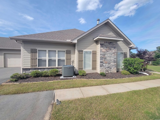 244 Mountain Terrace Cir, Maumelle, AR 72113 - view of front of home featuring cooling unit, stone siding, a garage, roof with shingles, and driveway