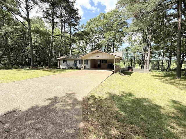 view of front of home featuring driveway, an attached carport, and a front yard