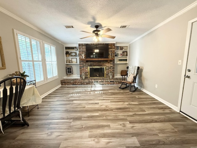 living area with a textured ceiling, visible vents, wood finished floors, and ceiling fan