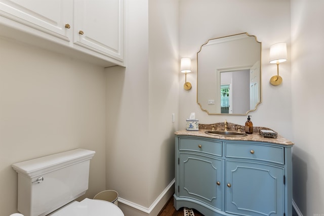 bathroom with toilet, baseboards, and vanity