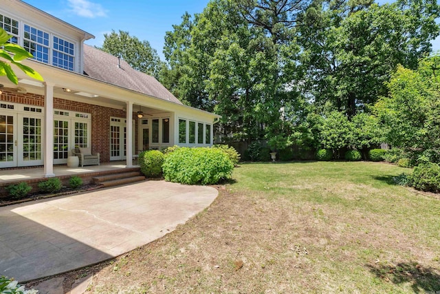 view of yard with a patio, french doors, ceiling fan, and fence