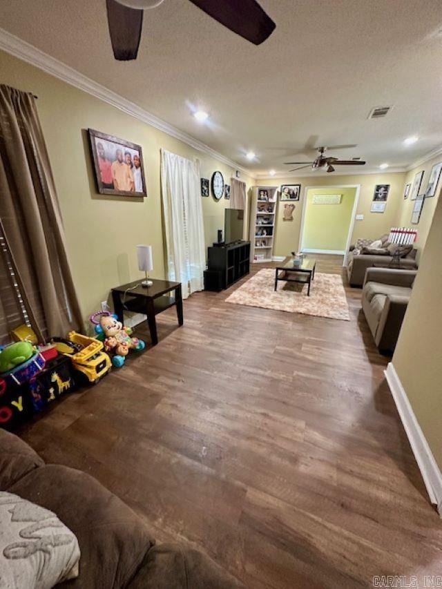living area featuring a textured ceiling, visible vents, wood finished floors, and ceiling fan