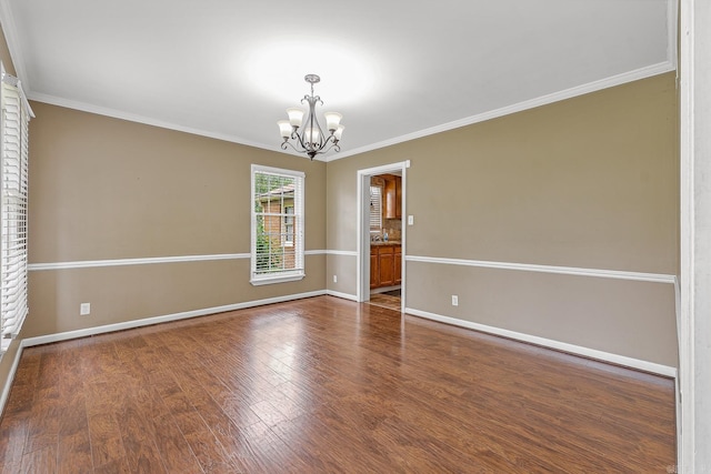 720 N 18th St, Blytheville, AR 72315 - empty room with baseboards, ornamental molding, an inviting chandelier, and wood finished floors